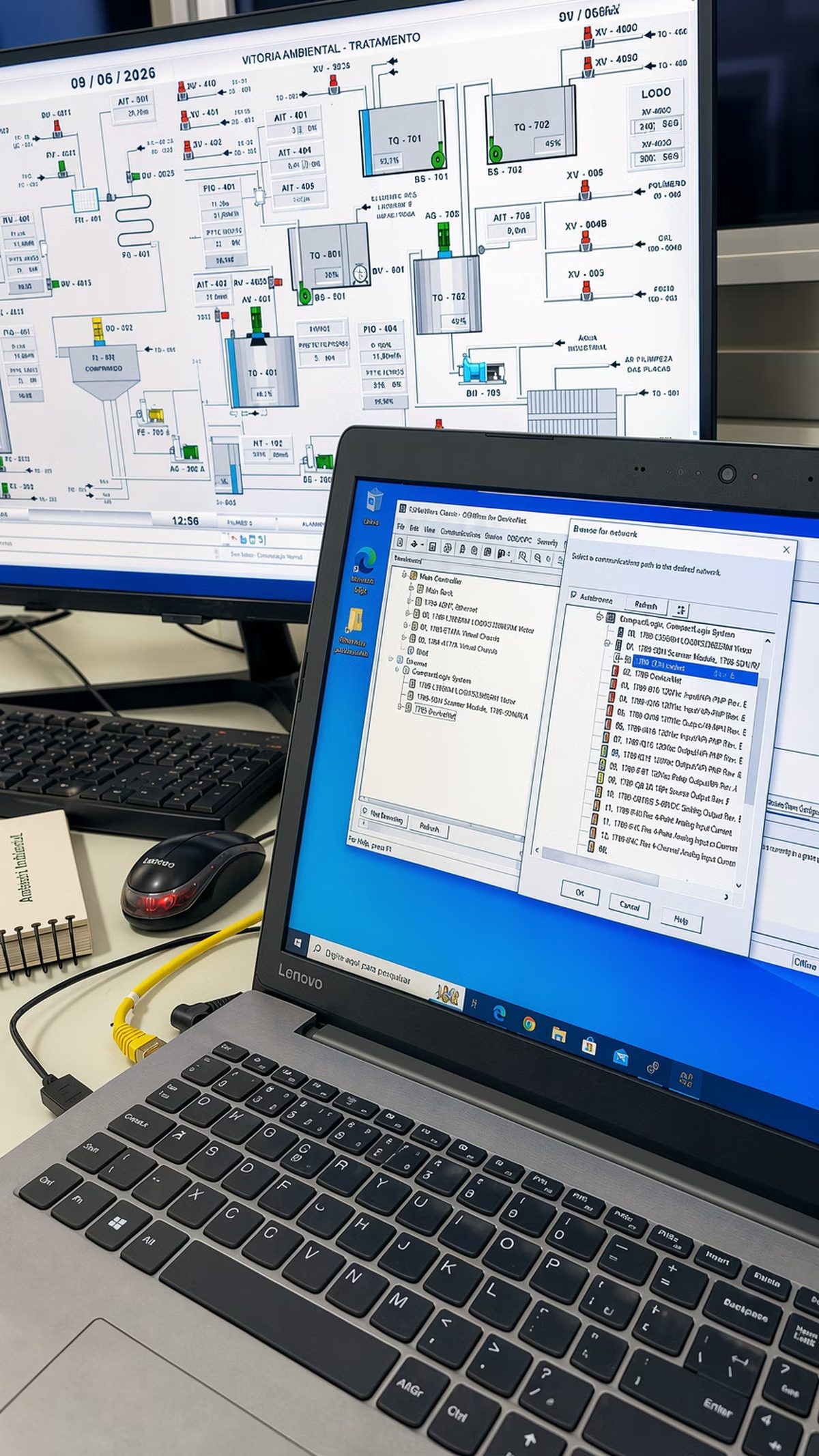 Tela de supervisório industrial e notebook com configuração de software de automação